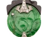 an antique jade and diamond broochle with a cross on it