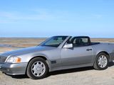 mercedes sl - class convertible parked on a gravel road near a body of water