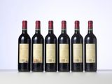 six bottles of red wine lined up in a row