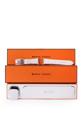 une montre blanche posée sur une boîte orange