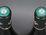 two bottles of wine sitting next to each other on a table
