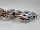 three glass fish figurines sitting on a white surface