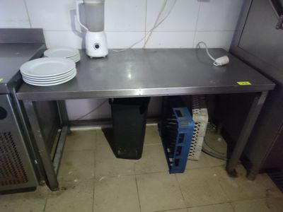 une table en métal avec des assiettes et des tasses dessus, dans une cuisine
