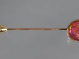a close up of a pink oplite stone on a gold stick