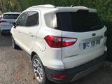 the rear end of a white car parked in a parking lot