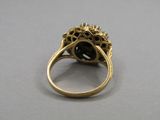 a close up of a gold ring with a black stone center