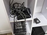 a white shelf with a bunch of electronics on top of it