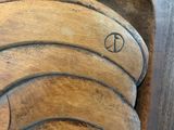 a close up of a wooden sculpture with a peace sign on it