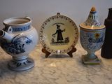 three vases and a plate sitting on a table