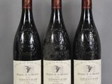 three bottles of wine are lined up on a glass table