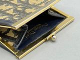 un sac à main doré et noir posé sur une table