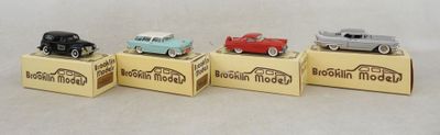 trois petites voitures miniatures sont posées sur une boîte en carton