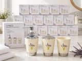 trois morceaux de savon et une lotion posés sur un plan de travail, à côté d'une boîte de savon