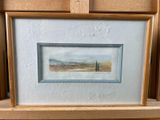 painting of a landscape in a wooden frame on a shelf