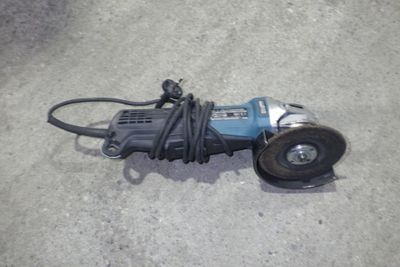 une photo d'une petite meuleuse électrique posée par terre