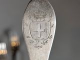 a silver spoon with a crest on it sitting on a table