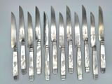six couteaux sont alignés sur une table