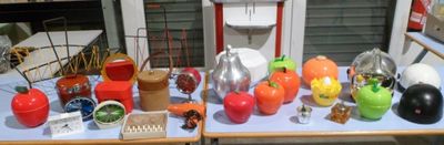 de nombreux vases de différentes couleurs posés sur une table à l'extérieur