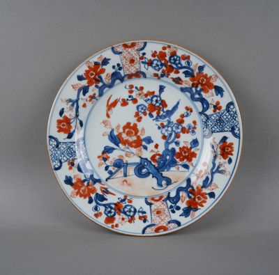 une assiette bleue et rouge décorée de fleurs