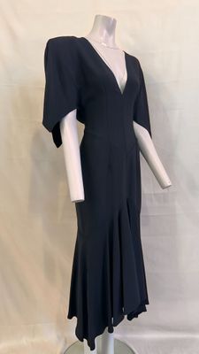 the dress is black and has a v - neck and flared skirt