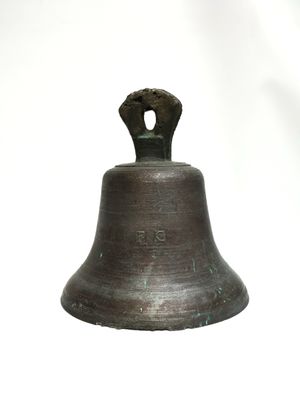 a metal bell that is sitting on a white surface