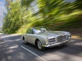 an image of a silver car driving down a road with trees in the background