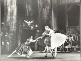 black and white photograph of a couple of dancers performing in front of a group of people