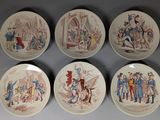 six plates with different designs of people on them on a wall