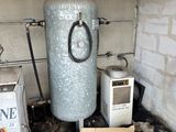 un chauffe-eau dans un coin de la pièce, à côté d'une pile de cartons