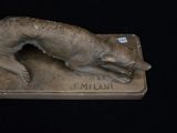 a statue of a dog that is laying down on a plaque