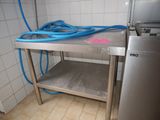 a metal table with a blue hose on top of it