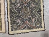 several pieces of cloth are laid out on the floor next to a person ' s feet