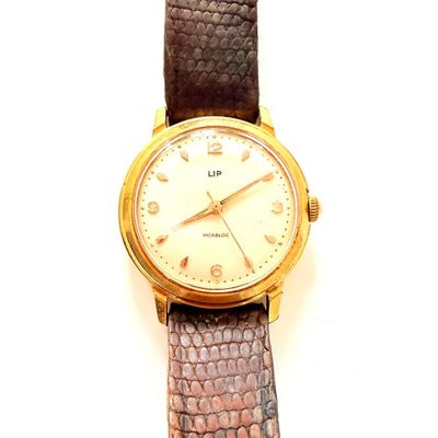 une montre posée sur une surface blanche