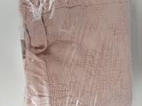 a pink blanket wrapped in plastic on a white surface