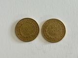 two gold coins on a white surface