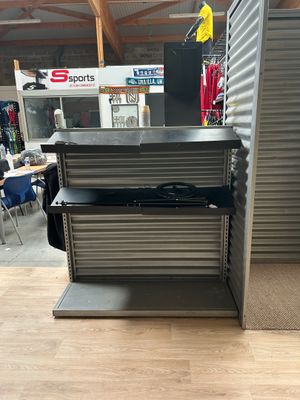 une photo d'une étagère métallique dans un magasin, sur laquelle sont disposés de nombreux articles