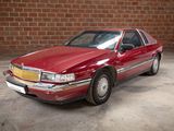 a red car parked in front of a brick wall