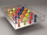 Des figurines en plastique aux couleurs vives sont disposées dans une vitrine transparente