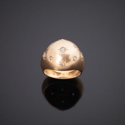 gros plan d'une bague en or avec des diamants sur une surface noire