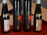 three bottles of wine sit on a table next to a wooden box