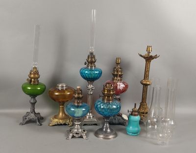 de nombreux vases en verre de différentes couleurs et des bougies sur la table