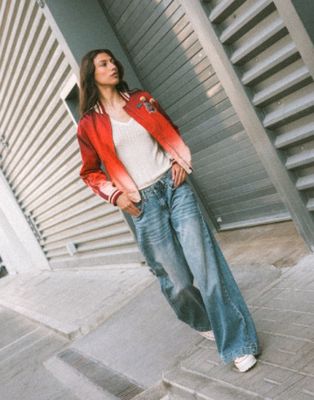 une femme qui se tient sur le trottoir, les mains dans les poches