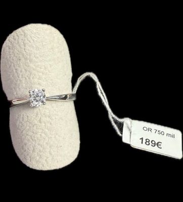 une bague sertie d'un diamant, avec une étiquette de prix attachée