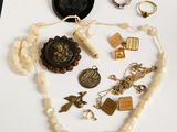 de nombreux bijoux posés sur une table blanche, à côté d'un téléphone portable