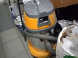 un aspirateur posé par terre à côté d'un sac poubelle