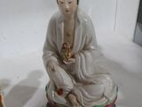 une statue représentant une femme assise sur une table
