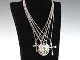 collier en argent orné d'une croix et d'un cœur, présenté sur un mannequin noir