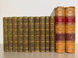 several old books are lined up in a row on a table