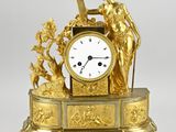 une horloge en or surmontée d'une statue