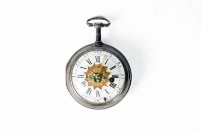 une montre de poche en argent ornée d'un lion en or sur le cadran